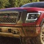 A 2021 Red Nissan Titan truck off roading in dirt_mobile