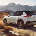 A 2021 White Nissan Rogue driving on a mountain pass_mobile