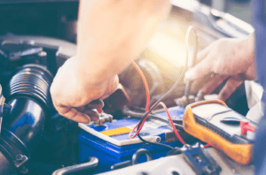 Close up of car technician working on car battery