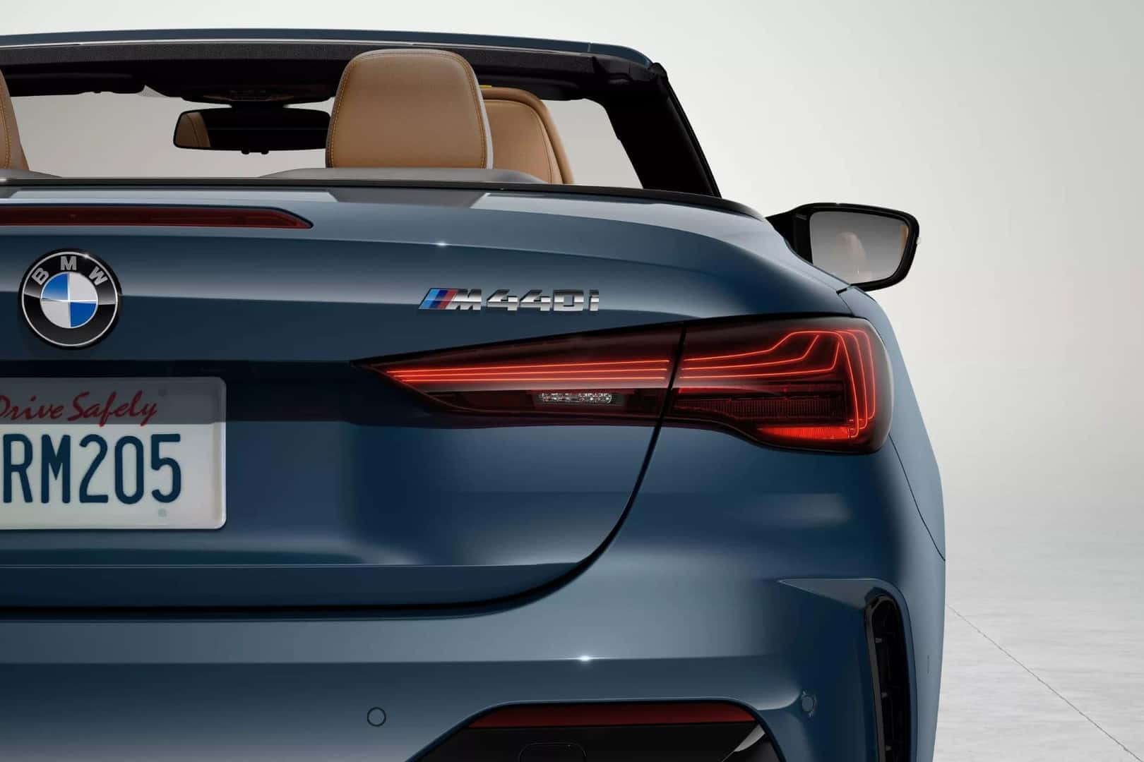 Rear view of the BMW 4 Series convertible in blue, highlighting the M440i badge and stylish taillights.
