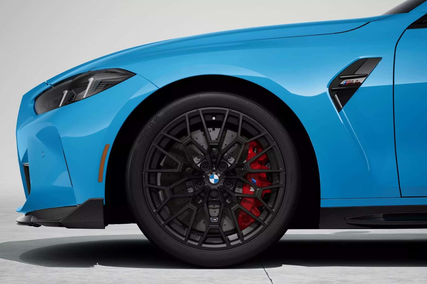 Close-up of the BMW M4 coupe's front wheel with stylish black alloy rims and red M performance brakes.