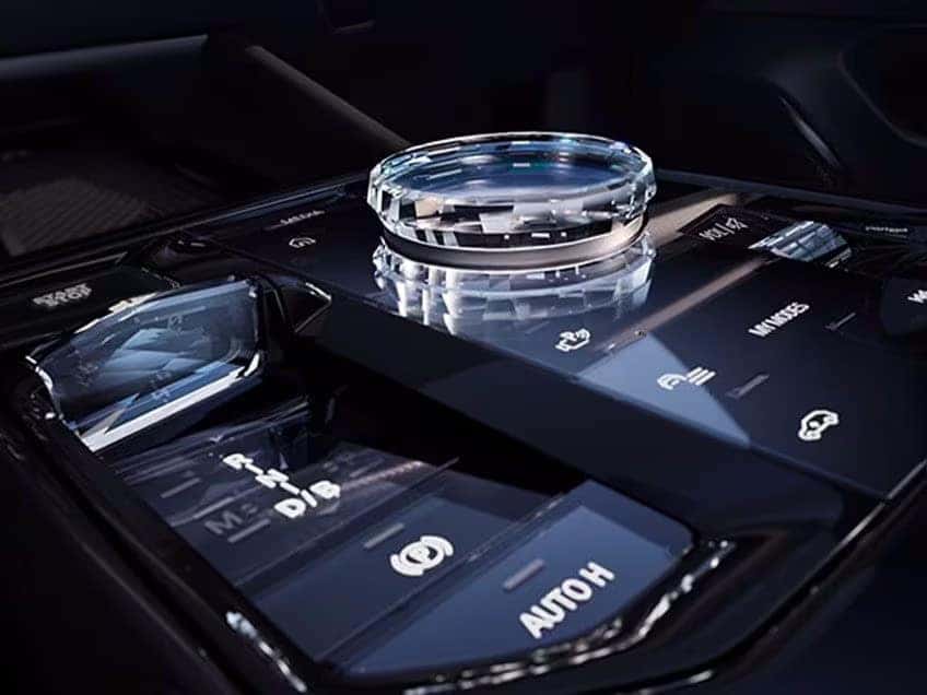 Close-up of the BMW crystal iDrive controller and touch-sensitive panel in the center console.