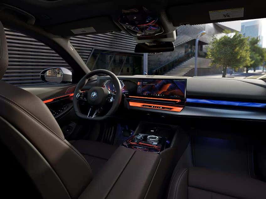 BMW i5 interior featuring ambient lighting, a digital dashboard, and a modern infotainment display.