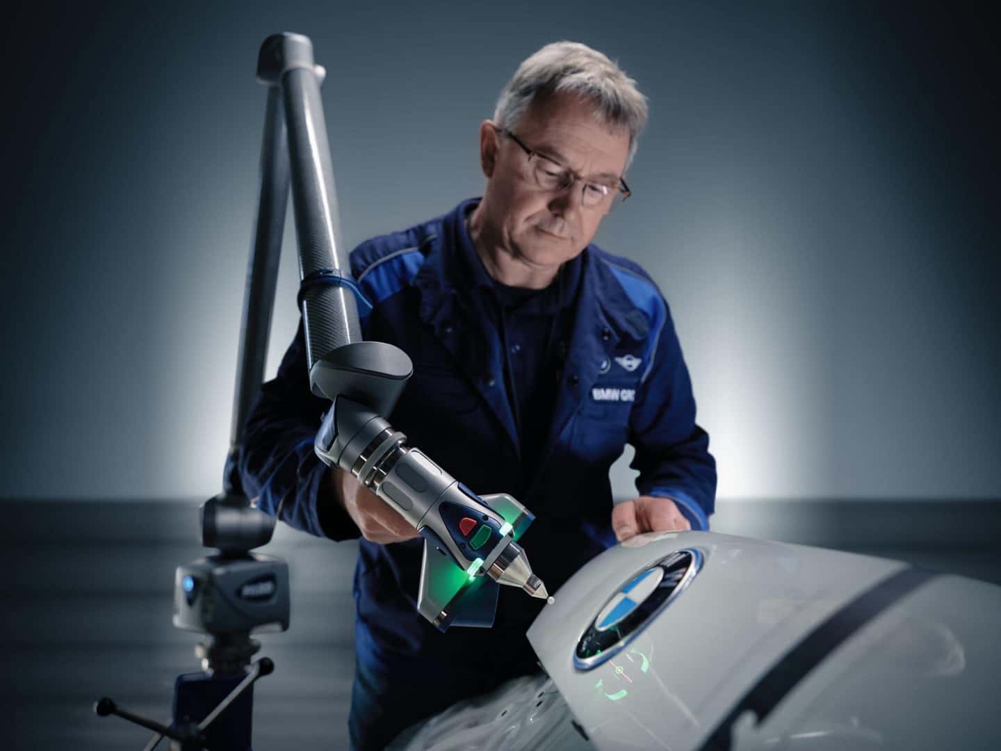 BMW engineer using an advanced 3D scanning device to inspect the surface of a BMW vehicle.