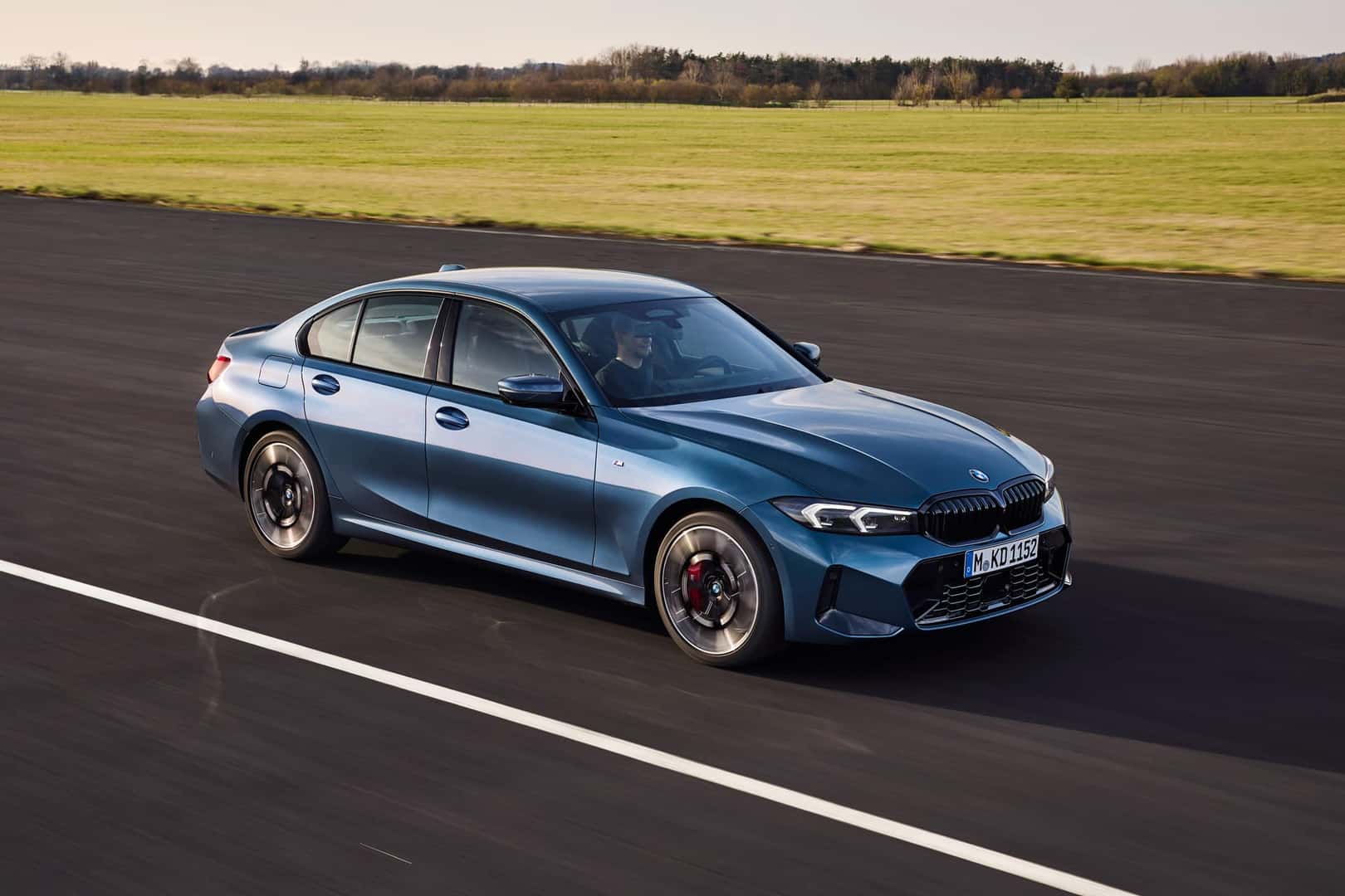 2025 BMW 330i in motion on a race track, highlighting its sleek and aerodynamic design