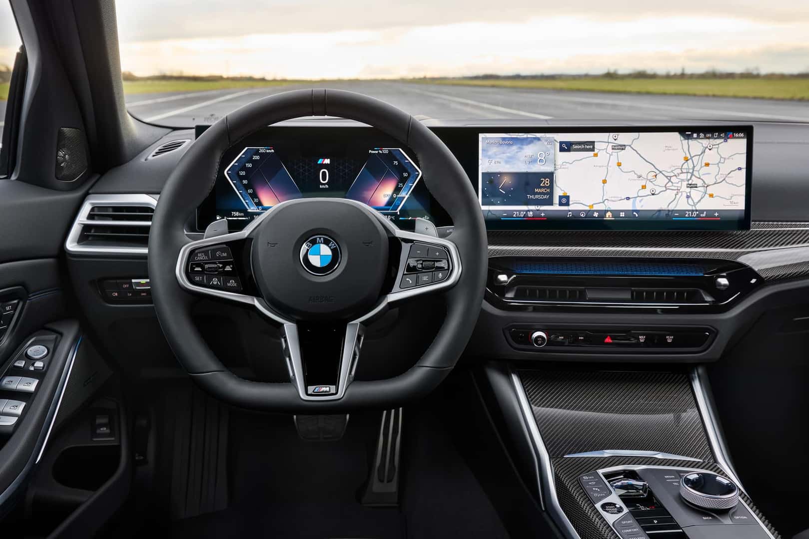 Interior dashboard view of the 2025 BMW 330i Sedan featuring a digital display and steering wheel with BMW logo.