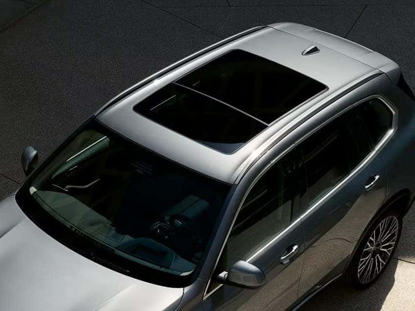 Top-down view of a silver 2026 BMW X5 featuring a panoramic sunroof