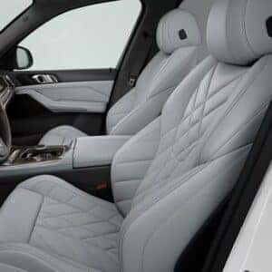 Front seats of the 2026 BMW X5 with quilted light gray leather upholstery