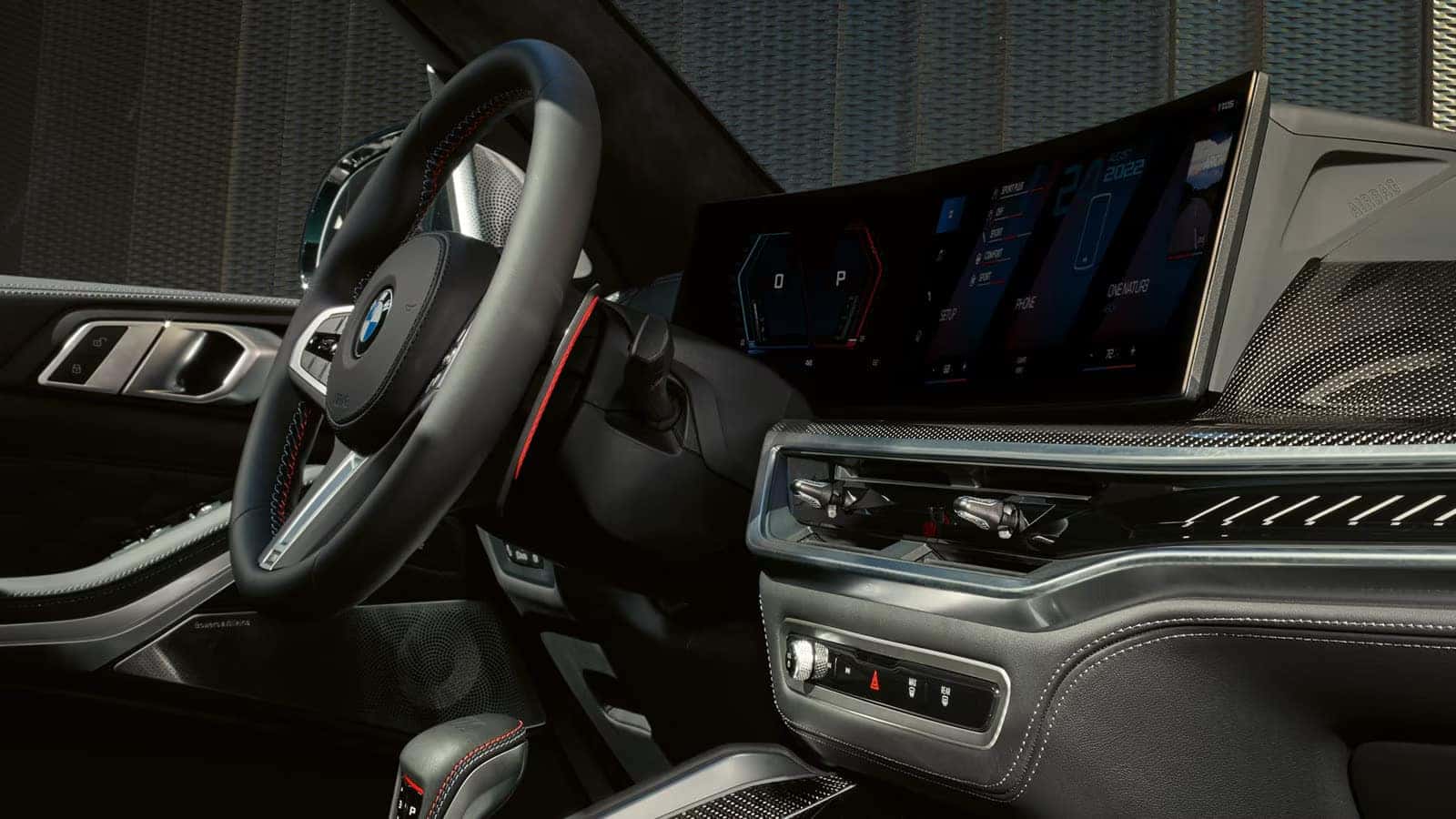 2026 BMW X5 M interior showcasing digital dashboard and center console with red accent stitching