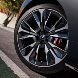 up close of the driver's tire on a bmw ix m70 showcasing the red brake calipers
