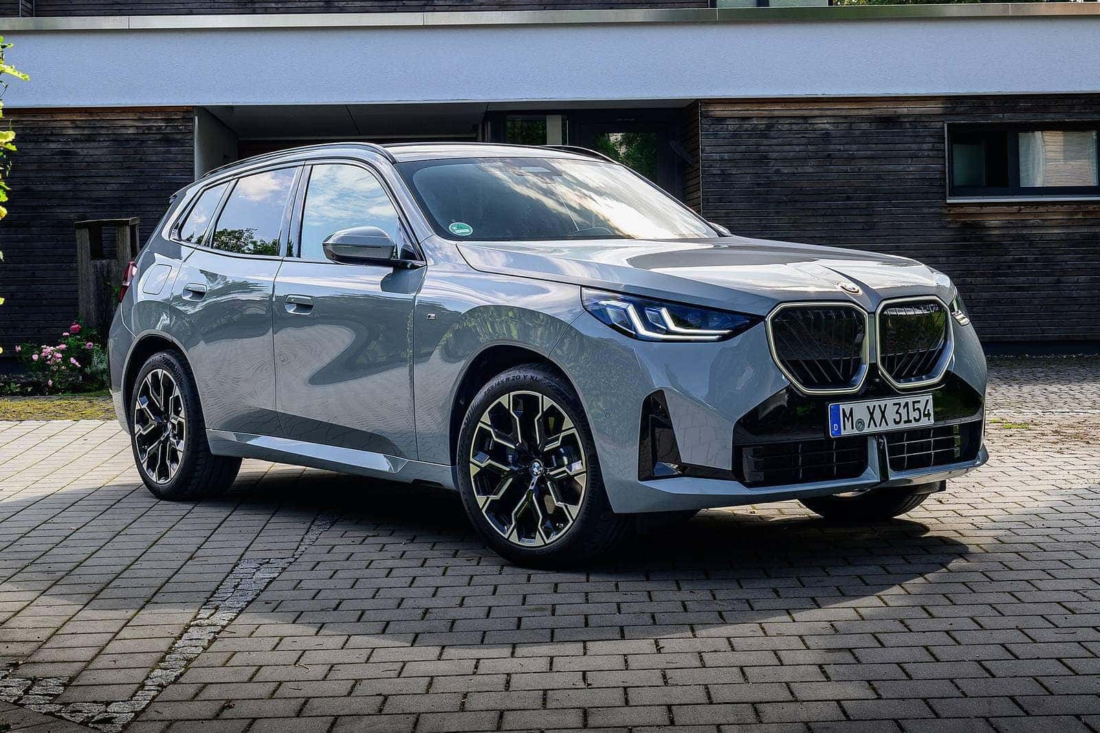 2026 bmw x3 parked on a brick paved area next to a building