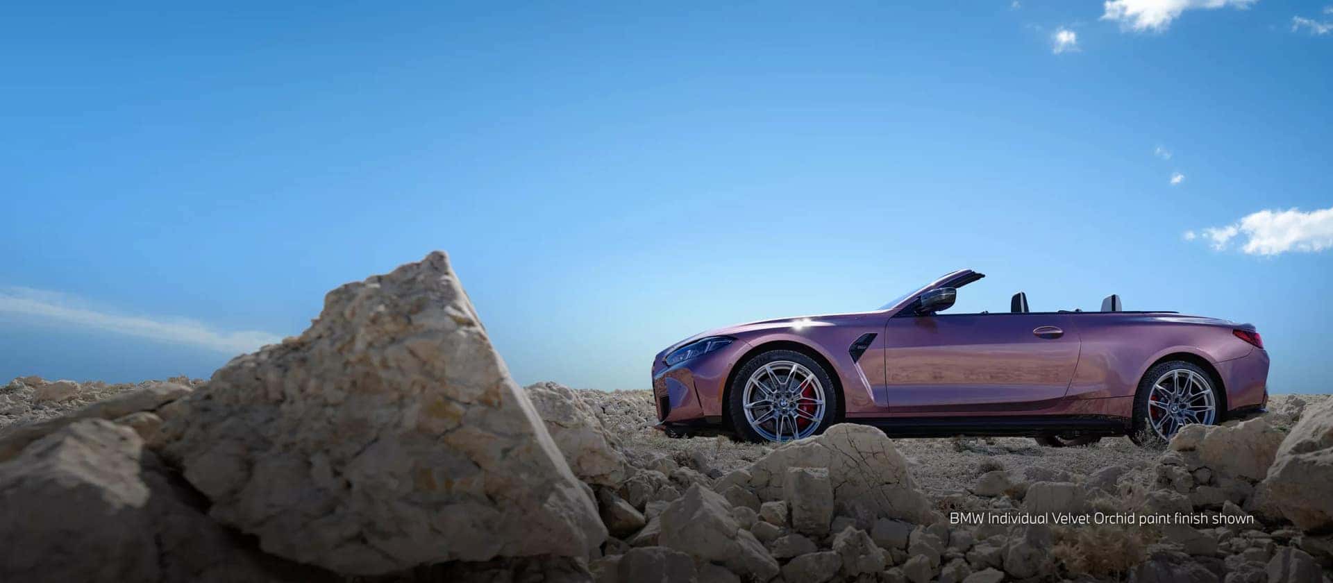 2026 BMW 4 Series parked next to a big rock
