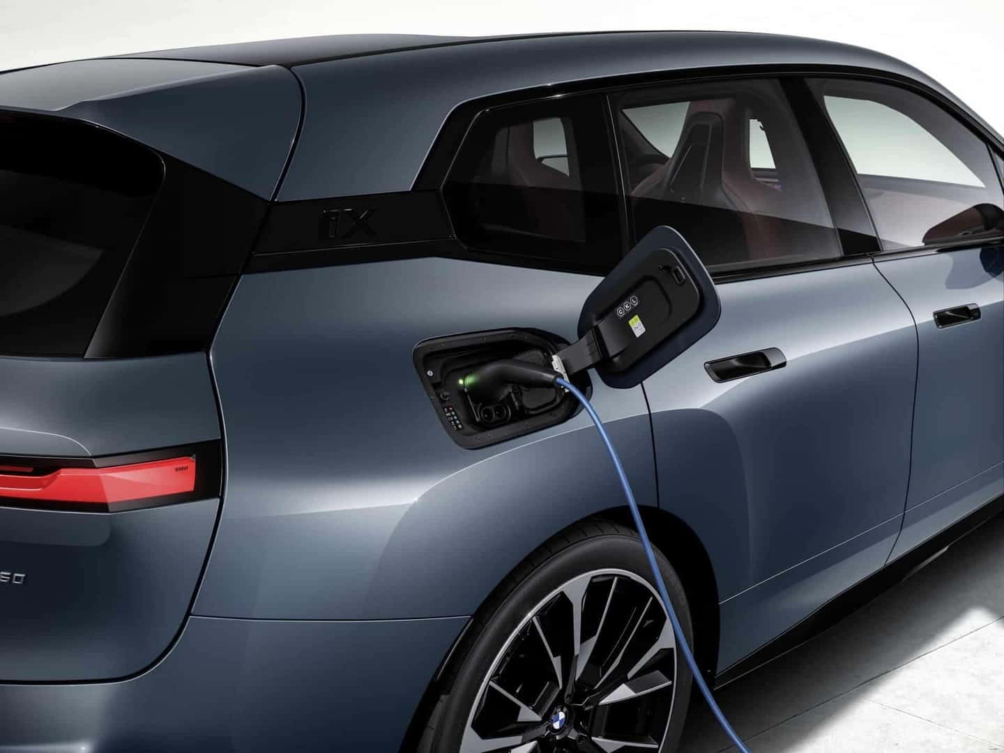 2026 BMW IX plugged into a charger