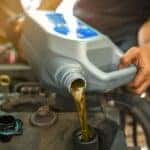 Car Mechanic Pouring New Oil in Engine - Desert 215 Superstore