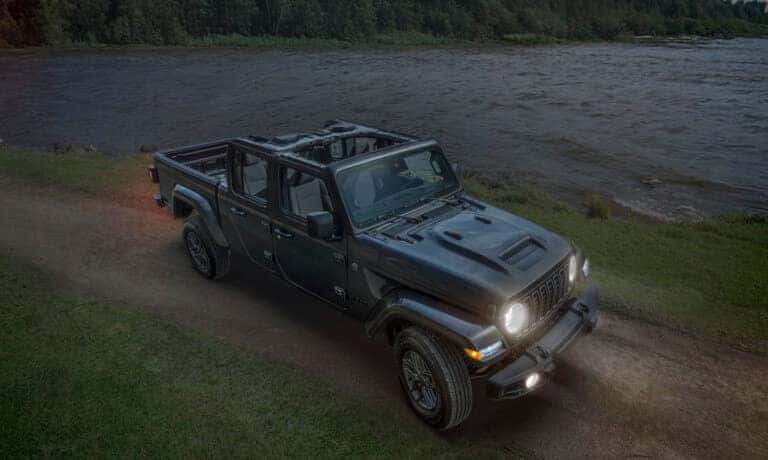 2026 Jeep Gladiator driving by lake with headlights