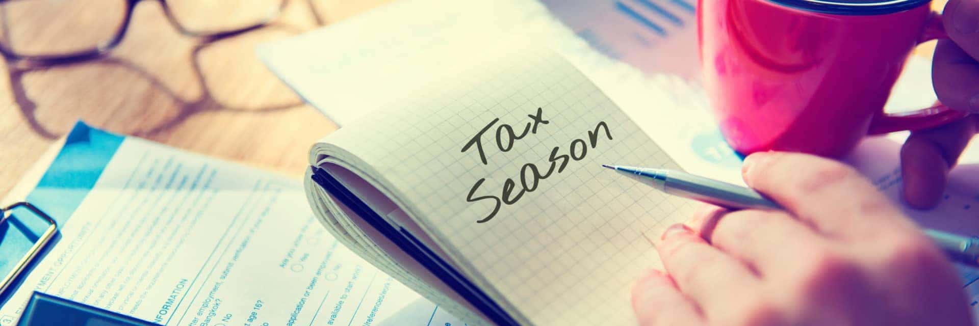 collage of tax items on desk and a notepad notating "Tax Season"
