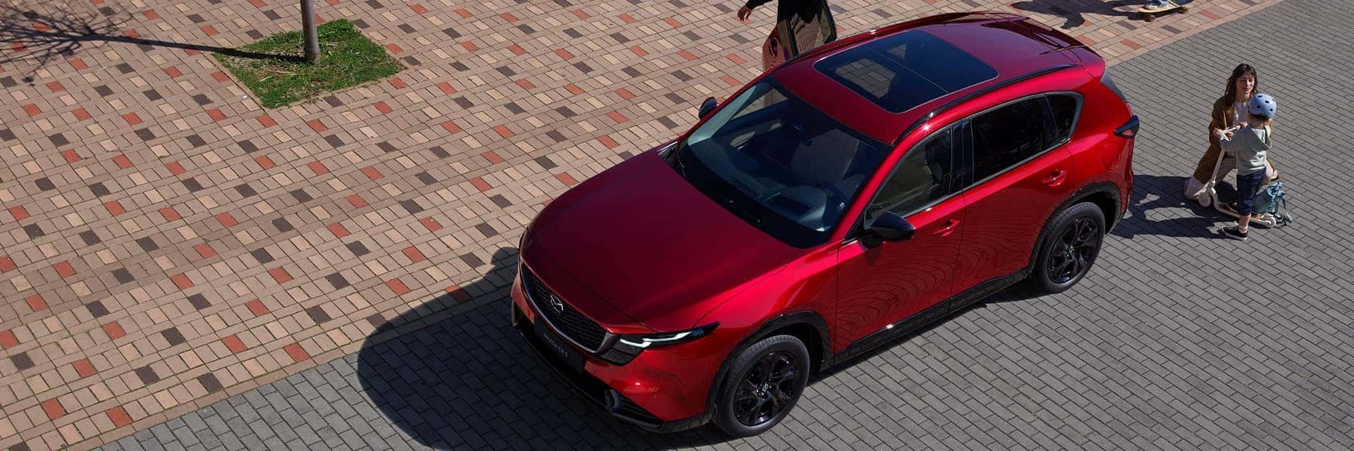 family next to red mazda cx-5