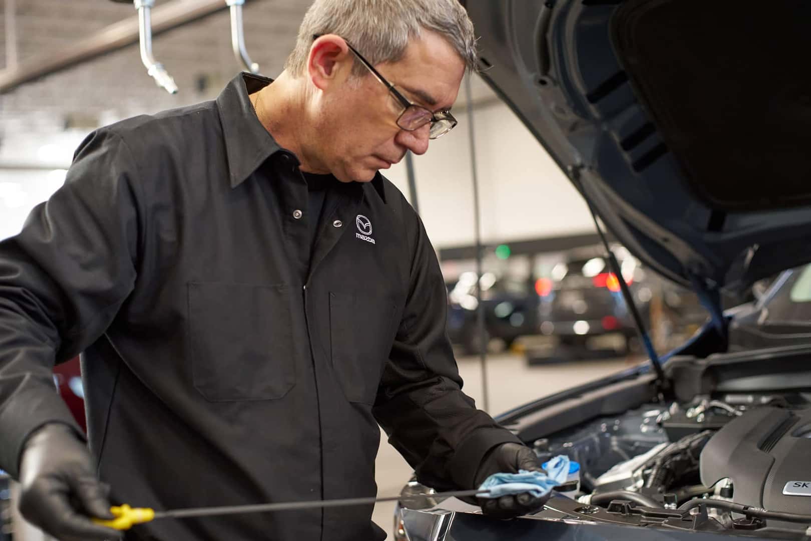 mazda service technician performing an oil change
