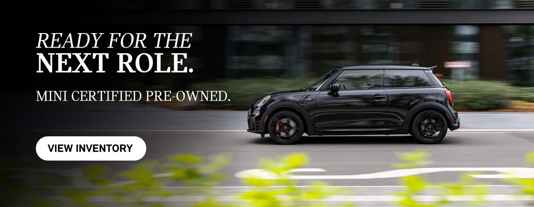 Side view of a black 2 Door driving down the road.