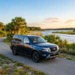 Dark blue Nissan Armada SUV parked on a paved coastal path during a scenic sunset. (Representative image for illustration purposes only. Actual vehicle may vary based on trim and configuration.)