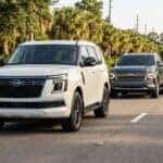 A white Nissan Armada drives down a suburban road followed by a grey Chevrolet Tahoe SUV. (Representative image for illustration purposes only. Actual vehicle may vary based on trim and configuration.)