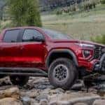 Red GMC Canyon Pickup Truck Rocks Water Mountains