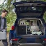 Man Woman Trunk Blue Buick Encore GX SUV Outside Trees