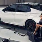 Technicians servicing a white 2020 Toyota Camry