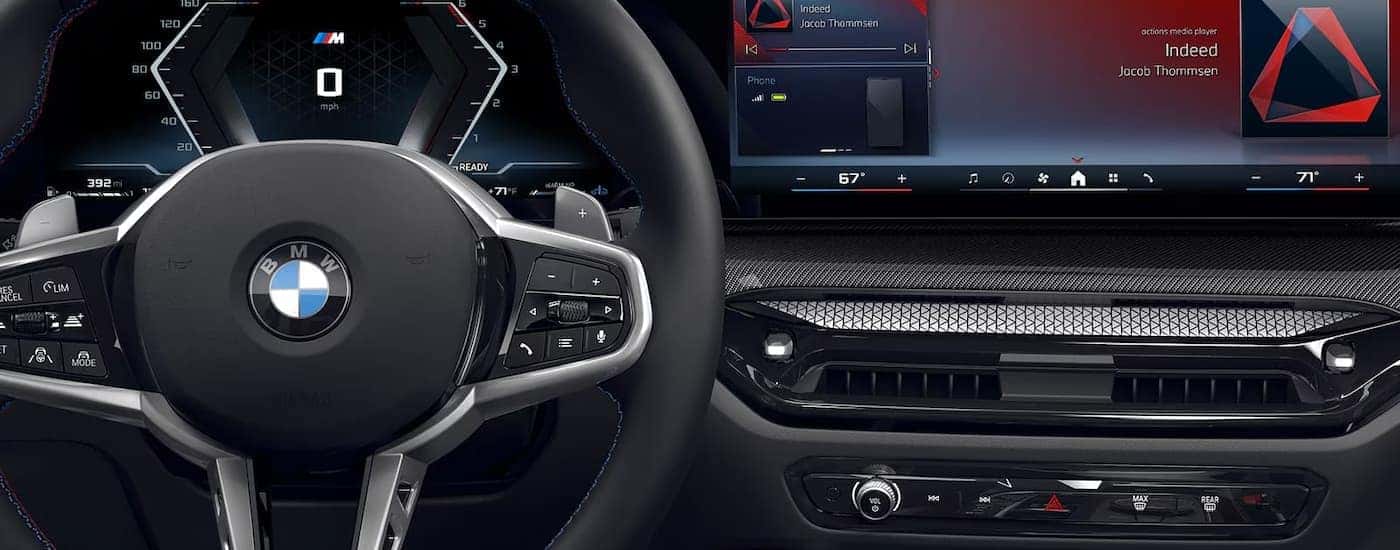 A close up of the steering wheel and infotainment screen in a 2025 BMW 2 Series.
