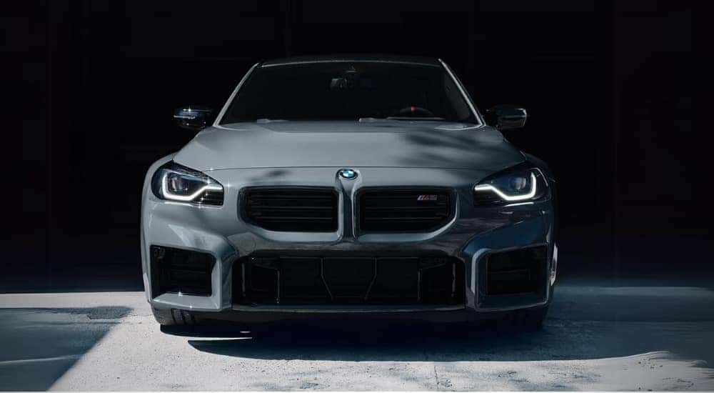 A grey 2025 BMW M2 is shown from the front.