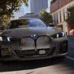 Head-on view of a grey 2025 BMW i4 eDrive40 charging at a public charging station.