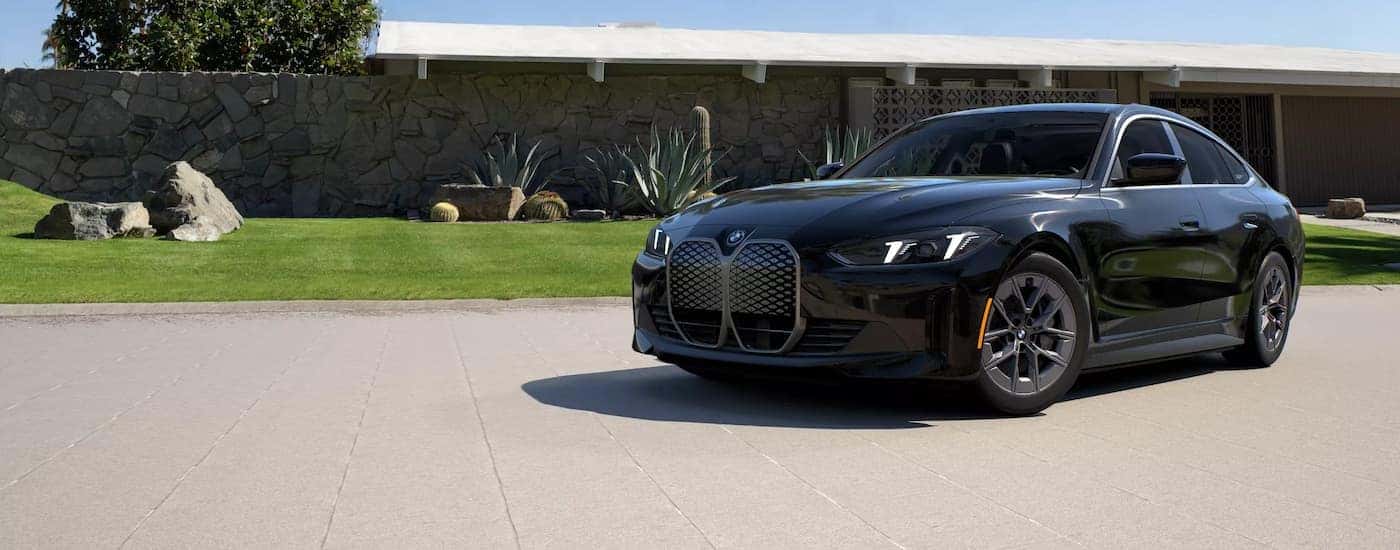 A black 2025 BMW i4 eDrive40 parked on a driveway.