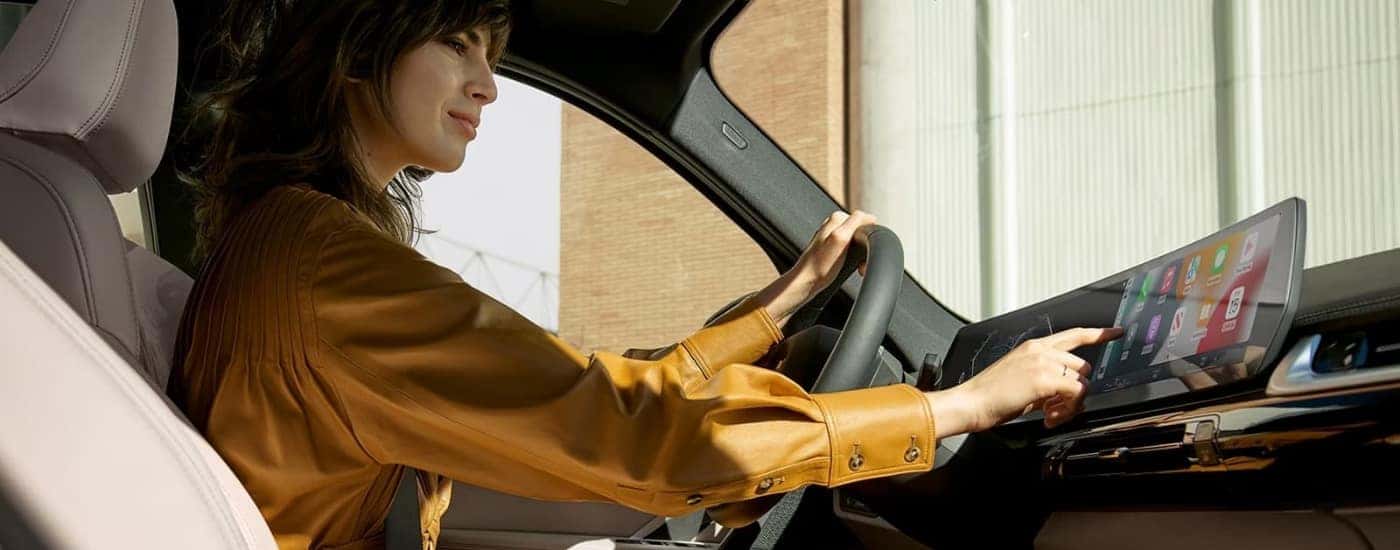 A person is using the infotainment screen in a 2024 BMW X1.