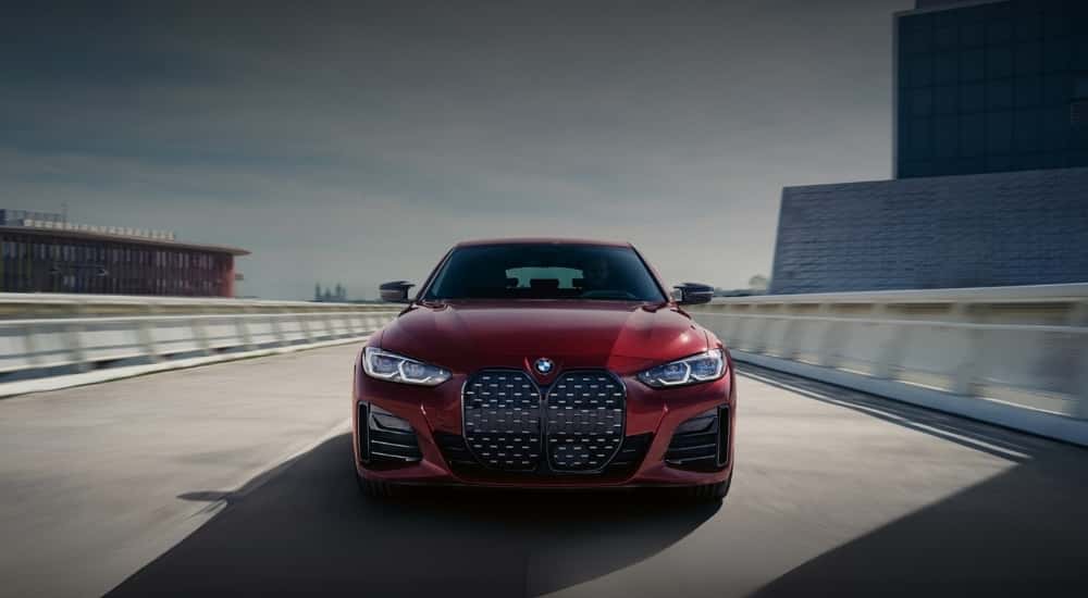 A red 2022 BMW 430i Gran Coupe driving over a bridge.