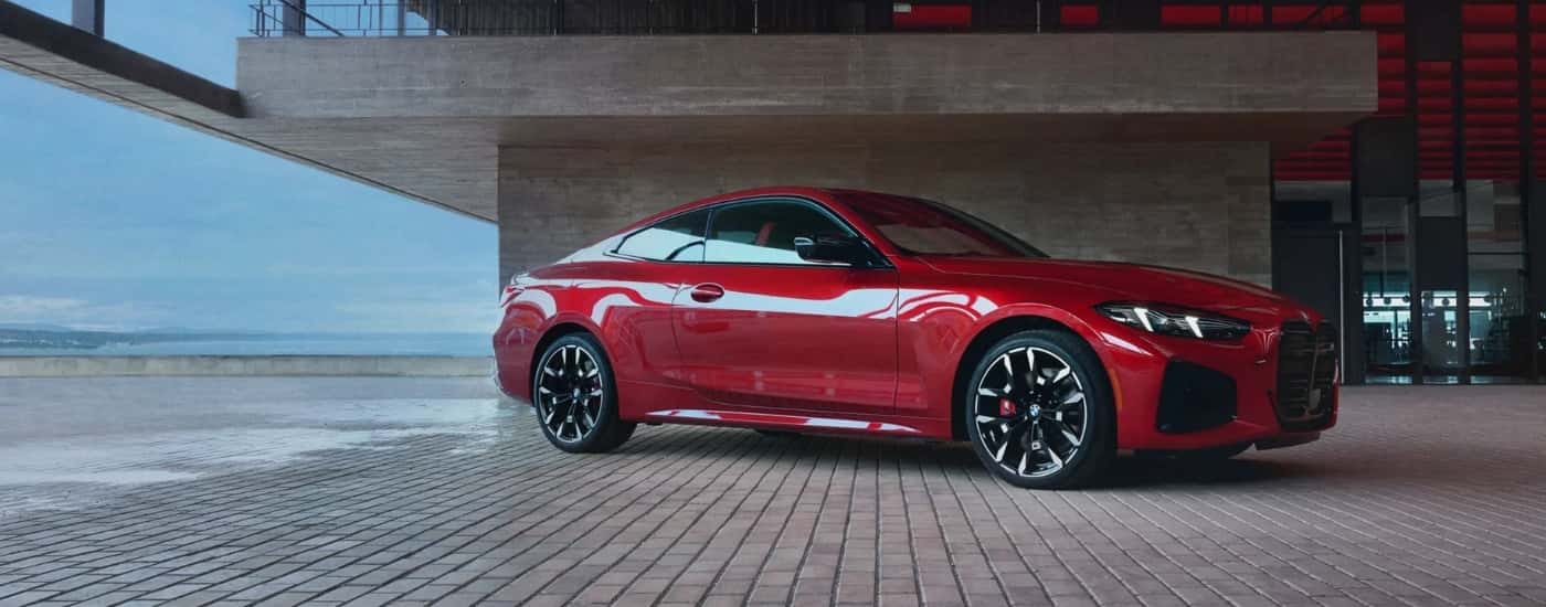 A red 2025 BMW M440i Coupe is parked in a hotel lobby.