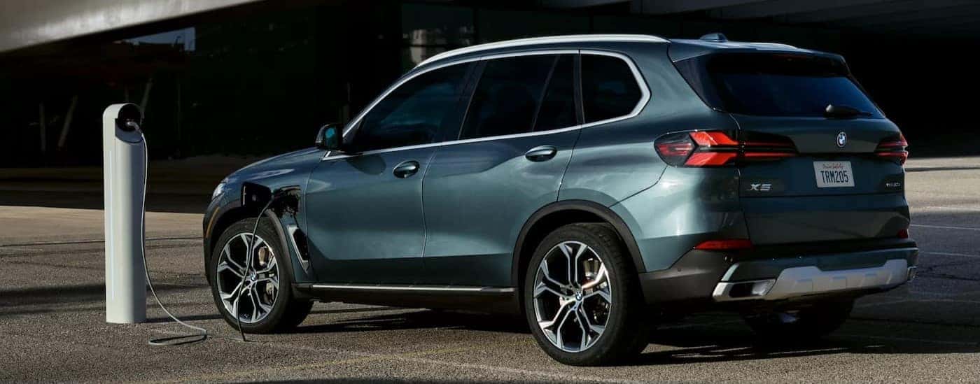 A green 2026 BMW X5 for sale in Roanoke is charging.