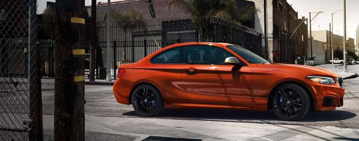 Orange 2019 BMW 2 Series stopped at an intersection.