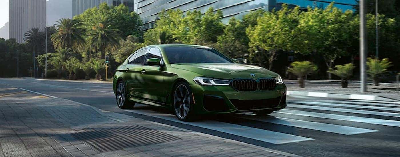 Green 2022 BMW Series 5 parked at a crosswalk