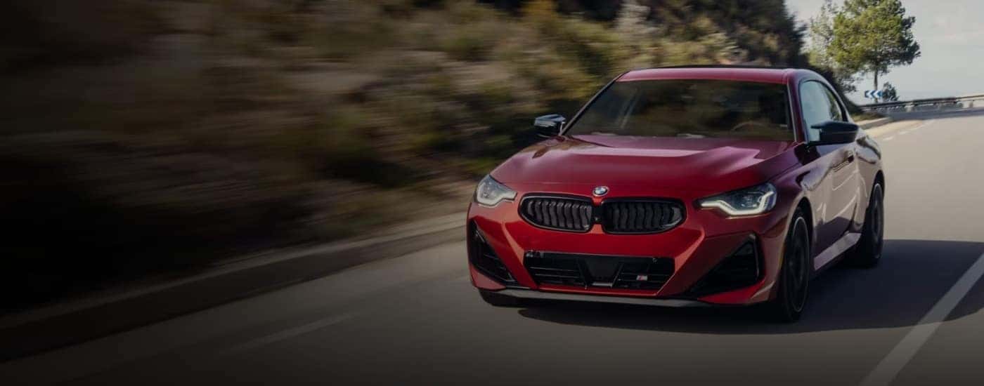 Red used 2025 BMW 2-Series for sale near Hollins driving on a road