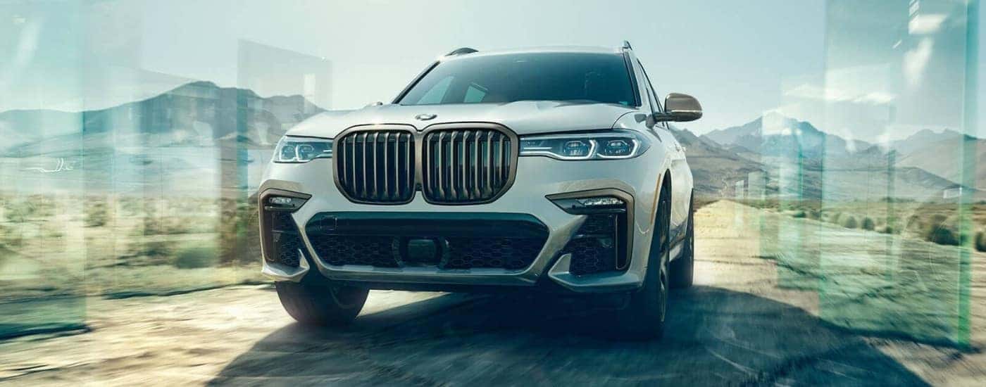 A white 2022 BMW X7 driving off-road.