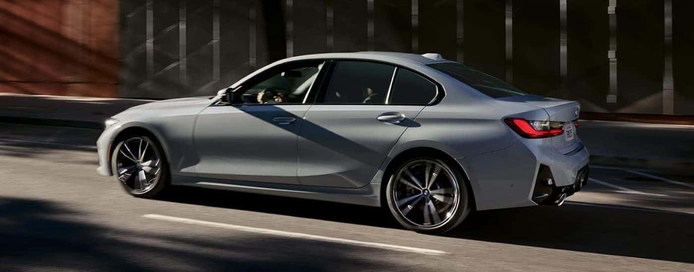 A grey 2024 used BMW 3 Series for sale near Salem driving on a street.