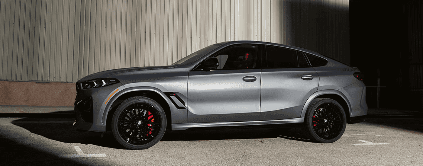 Silver 2025 BMW X6M parked outside a BMW dealer near Martinsville