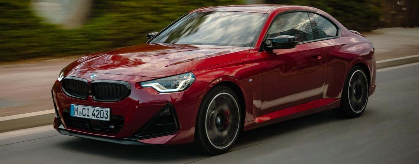 A red 2026 BMW M240i from the front at an angle.