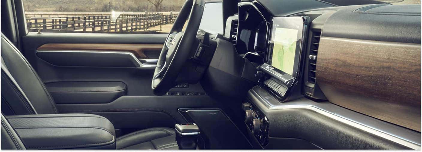 Black leather interior of a 2026 Chevrolet Silverado 1500 showing the steering wheel and infotainment screen.