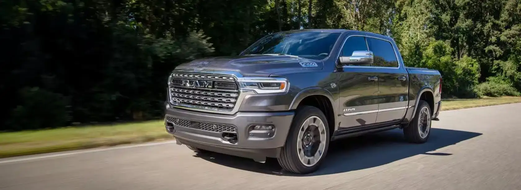 2027 RAM 1500 driving down a tree-lined road near Alvin, TX