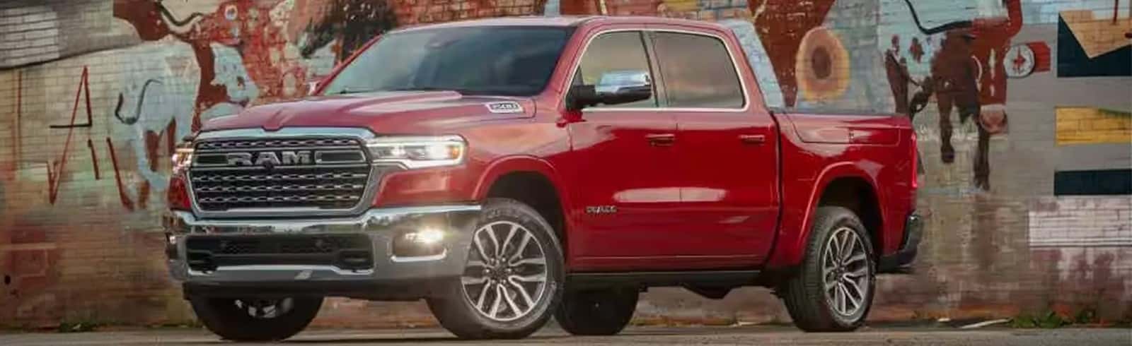 Red 2027 RAM 1500 parked in front of a graffiti mural