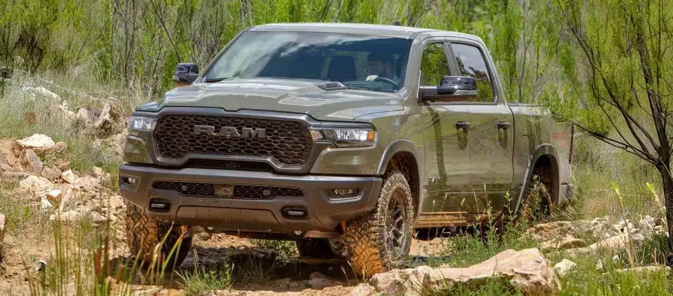 2027 RAM 1500 with lifted suspension crossing a rocky trail