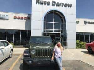 Lady standing next to her new Jeep at our dealership